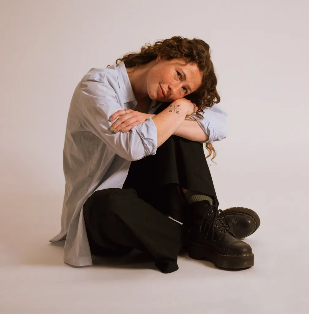Imogen Osborn sitting on the studio floor, smiling